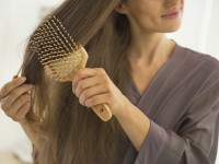 Closeup on young woman combing hair